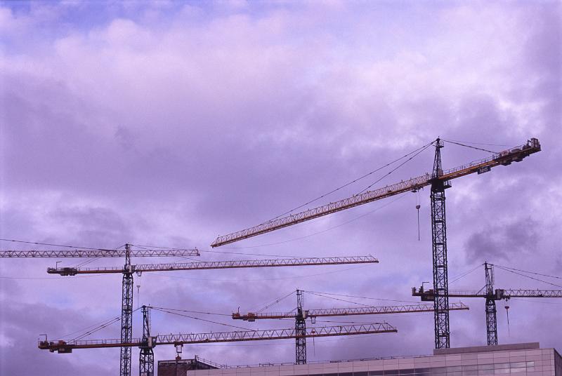 Free Stock Photo: Many construction cranes against purple stormy clouds, viewed from low angle