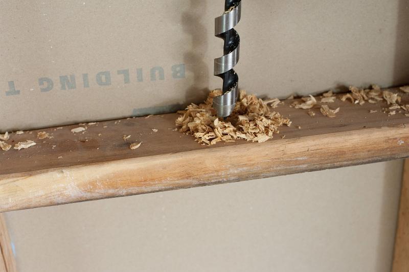 Free Stock Photo: Drilling a whole inside stud wall of the house for wiring electricity inside the wall