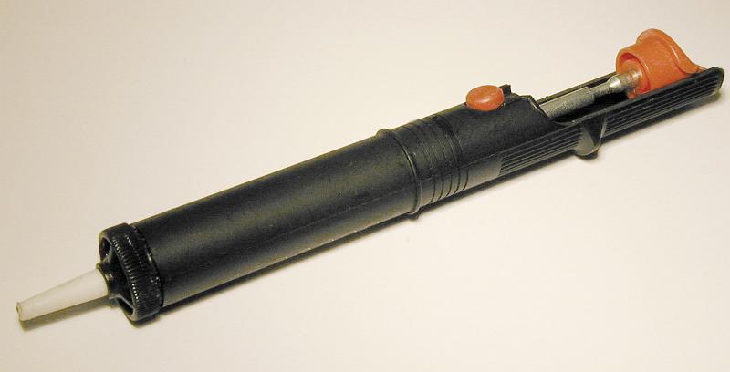Free Stock Photo: Small syringe style sucker or vacuum extractor with plastic casing lying diagonally on white with copy space