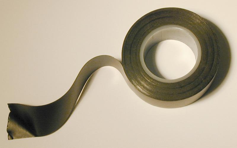 Free Stock Photo: Roll of black plastic insulation tape from above with one end unrolled over a white background with copy space