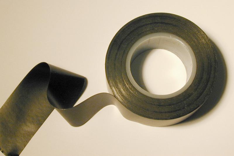Free Stock Photo: Roll of black electrical insulating tape with one end unrolled over a white background viewed from above