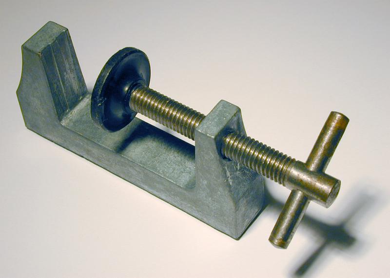 Free Stock Photo: Portable metal vice for clamping objects with circular plastic press on threaded steel viewed high angle on white