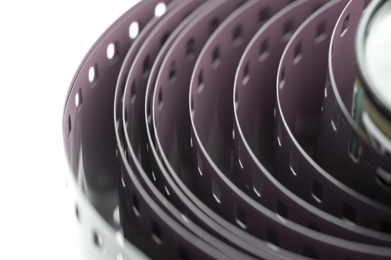 Free Stock Photo: Extreme cropped close up view on unraveled 35 mm film roll over white