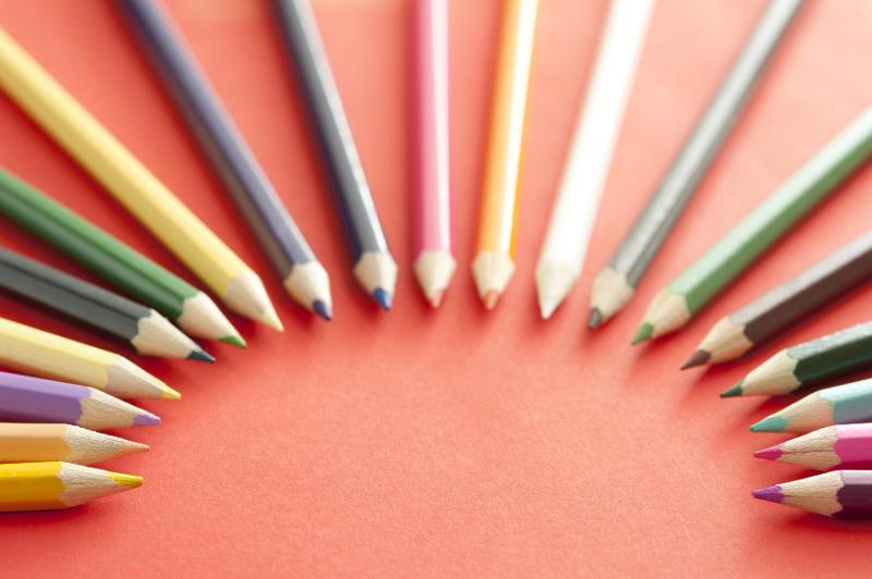 Free Stock Photo: An arch shape of various selected colored pencil tips pointing toward each other over red background