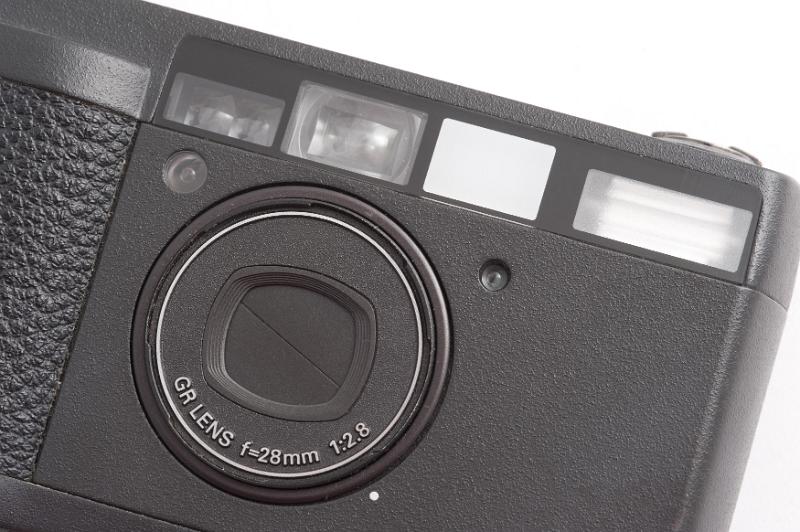 Free Stock Photo: Tightly cropped close up of compact pocket camera with closed lens over white background