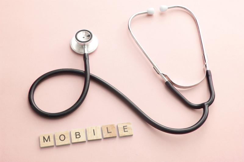 Free Stock Photo: Little blocks spelling the word mobile below professional web development concept with stetoscope over pink background