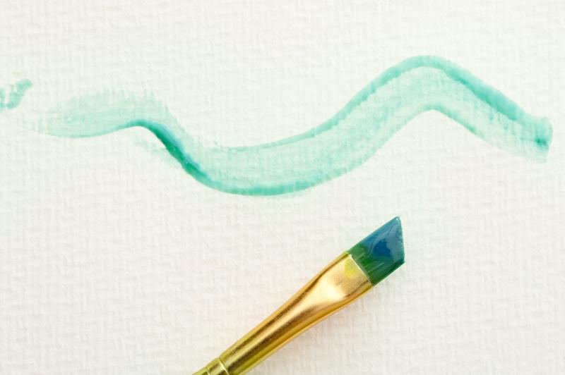 Free Stock Photo: Wavy line paint stroke in green with gold metal brush over textured paper with copy space