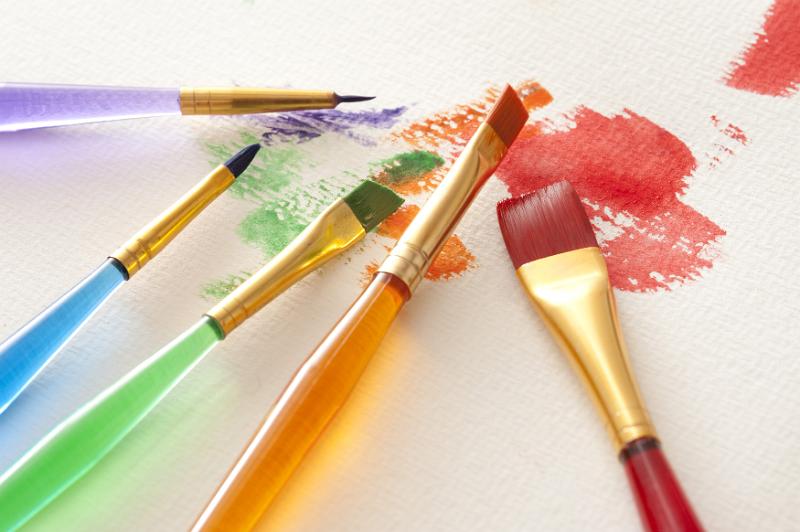Free Stock Photo: Close up on colorful set of various watercolor brushes and primary color paint strokes scattered on white textured canvas paper