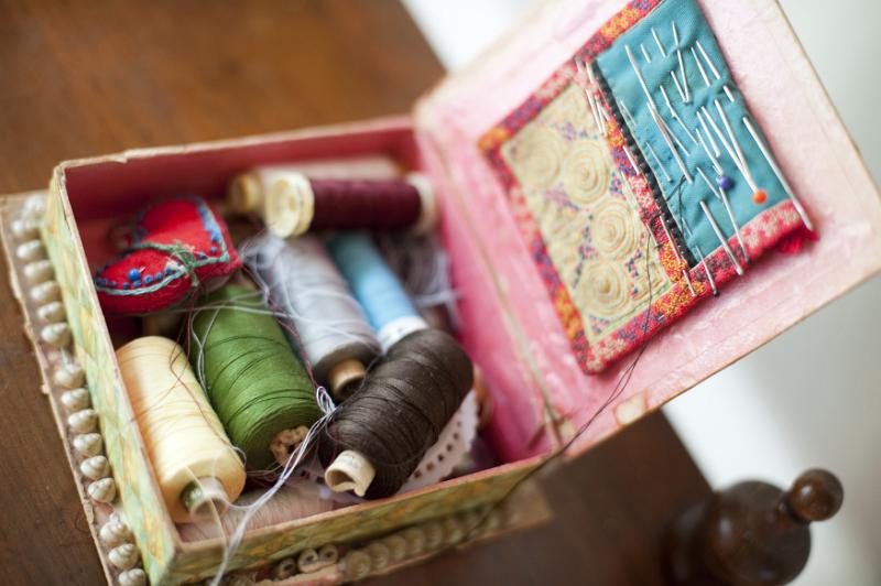 Free Stock Photo: Open sewing box with assorted colored reels of yarn or cotton, pins and needles viewed from above in a handicraft concept