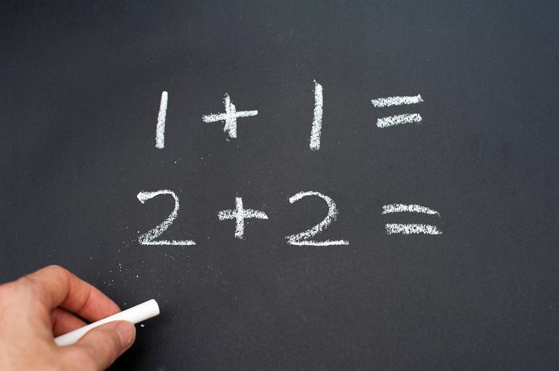 Download image of school chalkboard Free Stock Photo: Left-handed person writing numbers using white chalk.