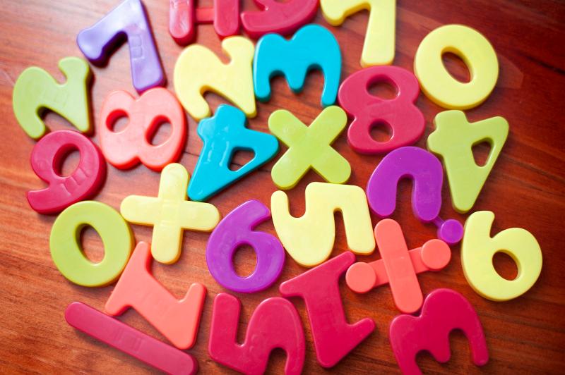 Free Stock Photo: Collection of random colourful plastic numbers and mathematical symbols for teaching young children in school