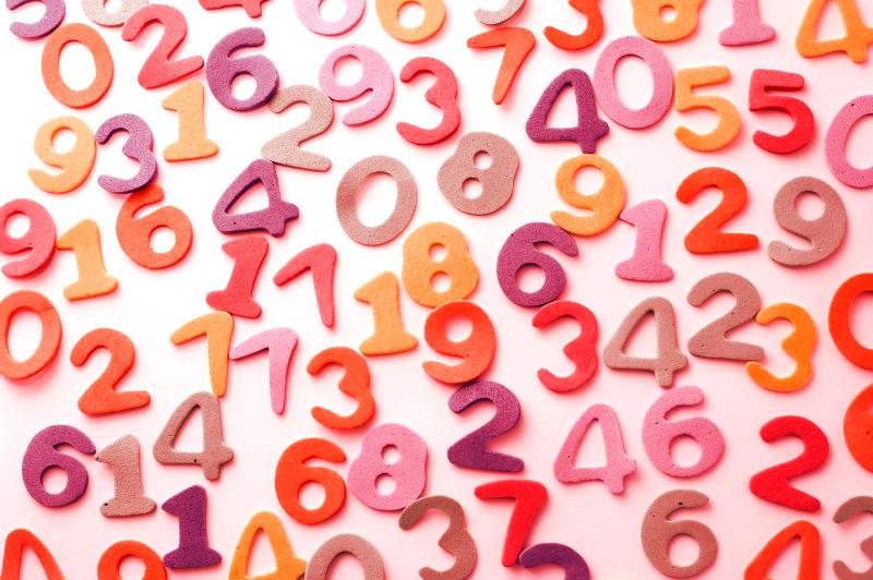 Free Stock Photo: Colourful array of numbers scattered randomly on a white surface in an education and learning concept for teaching young children mathematics