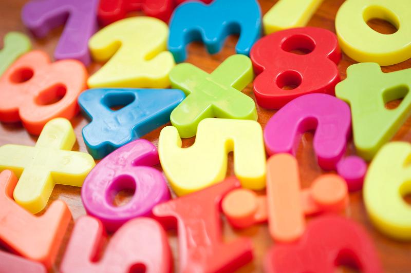 Free Stock Photo: Closeup of colourful plastic toy numbers and symbols for teaching kindergarten children basic mathematics