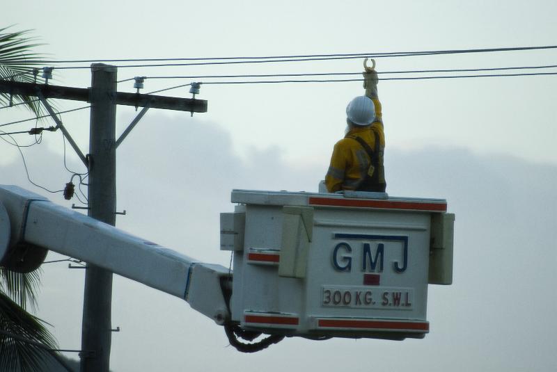 Free Stock Photo: a linesman taking current readings from a power line with a clamp meter