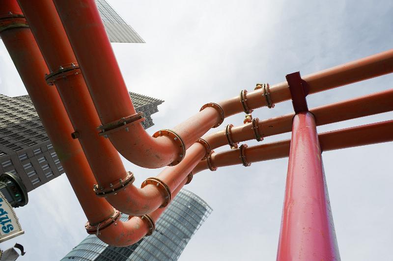 Free Stock Photo: pipes carrying water through a city with office blocks in the background