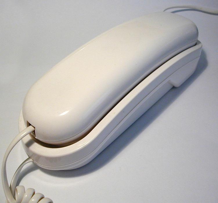 Free Stock Photo: Single wired white round edged plastic telephone with shadow over gray background