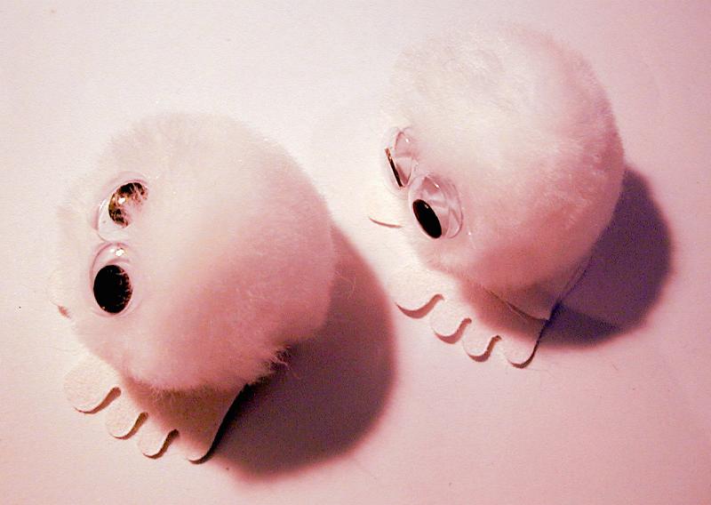 Free Stock Photo: Pair of pink furry toys with large round eyes and four toes on feet from top view