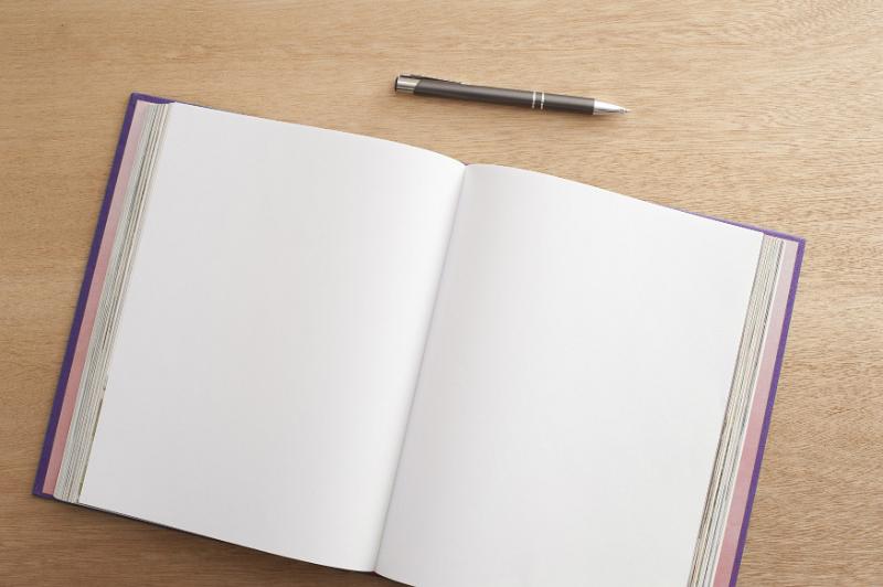 Free Stock Photo: View from above of the double page spread of an open blank notebook or journal with a pen above lying on a desk