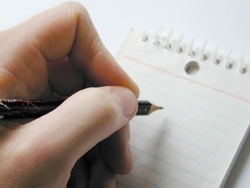 Free Stock Photo: First person perspective on sharpened pencil in hand over small blank notepad with lined sheets