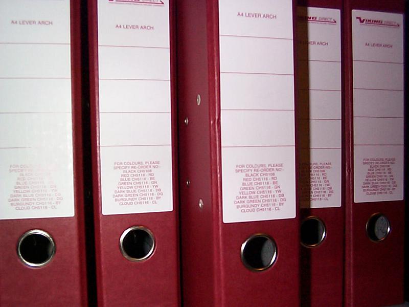 Free Stock Photo: Close up on spine of red binders with ringed holes used to pull them out of a shelf
