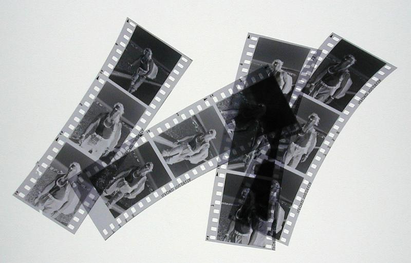 Free Stock Photo: Four strips of negatives cut into three sections over gray background or light table