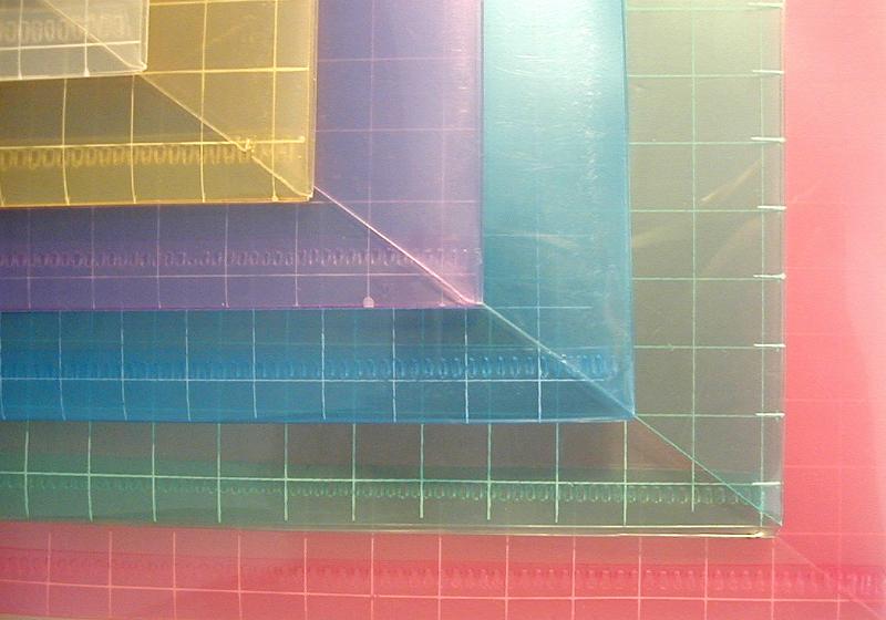 Free Stock Photo: Colorful sheets of colored plastic ruled with squares arranged offset with their corners aligned for a geometric background pattern