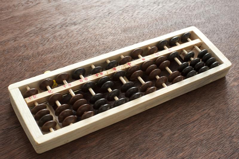 Free Stock Photo: Wooden abacus on a desk with its counters for manual computing, with copy space above