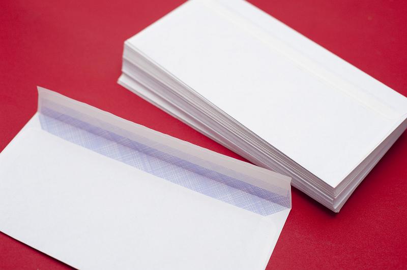 Free Stock Photo: Pile of blank white envelopes on a red background waiting to be filled with circulars or correspodence