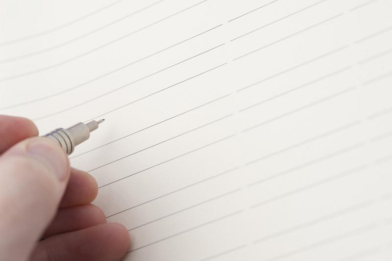 Free Stock Photo: Hand holding a mechanical pencil over a blank page ruled with lines for your message or text
