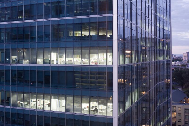 Free Stock Photo: Modern skyscraper office block at night with interior lights illuminated showing office furniture and layout