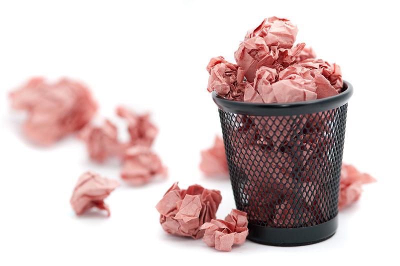 Free Stock Photo: Crumpled pink discarded paper overflowing from a waste paper basket in a messy office
