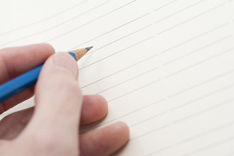 Free Stock Photo: Hand holding pencil ready to write your message or text on a blank lined sheet of paper