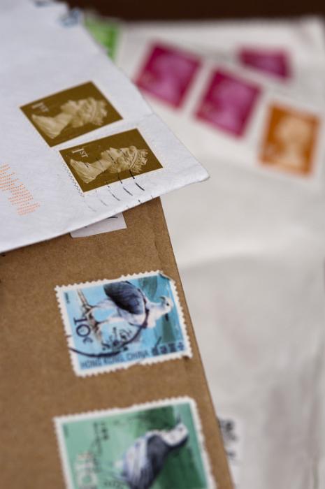 Free Stock Photo: Shallow dof closeup of cancelled UK postage stamps on brown and white envelopes