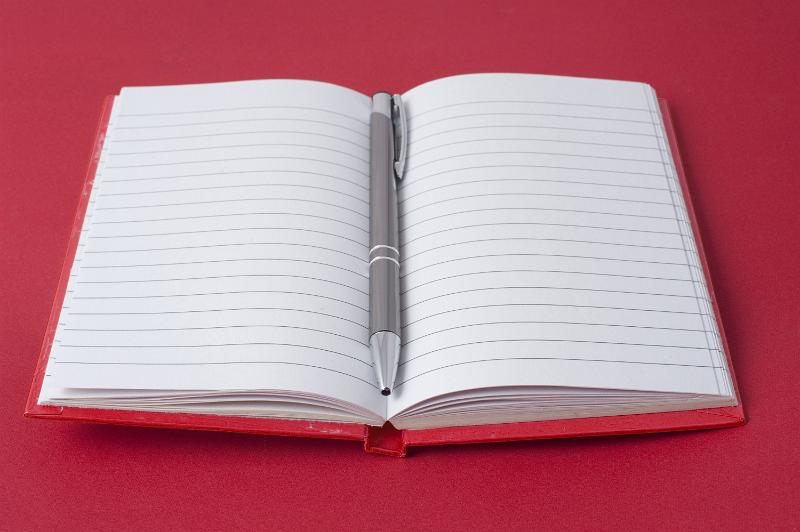 Free Stock Photo: Red notebook and ball pen on red background