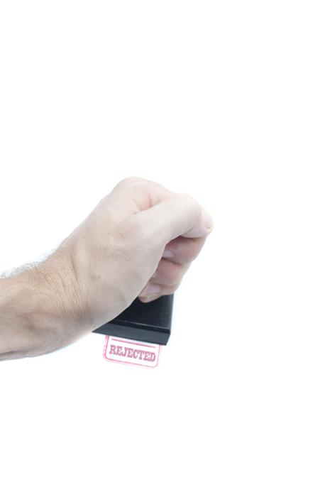 Free Stock Photo: Male hand using a Rejected office stamp and stamping a sheet of white paper with red ink