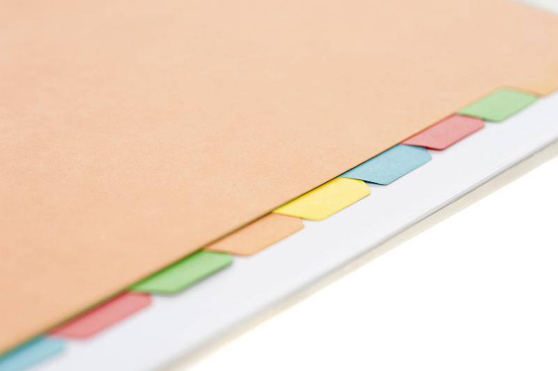 Free Stock Photo: Close view of some colored index tabs lined up in a manila folder against a white background