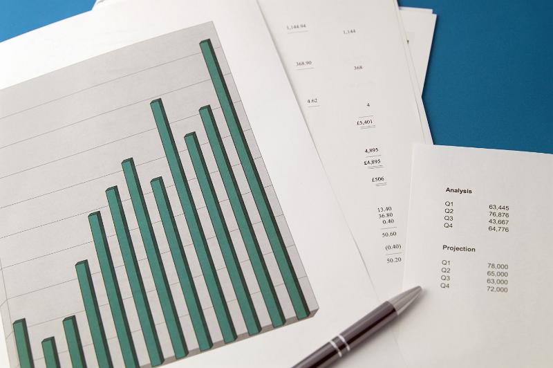 Free Stock Photo: An increasing bar graph and pen together with a sheet of statics in a concept of analysing graphs of increasing sales or turnover values
