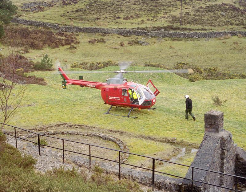 Free Stock Photo: Air ambulance parked in a field with the rotors turning as the medical team respond to an emergency