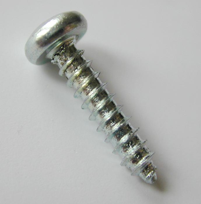 Free Stock Photo: Metallic screw with helical ridge or external thread, high-angle close-up, with copy space on gray